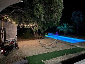 a motorcycle parked in front of a pool at night at Maison de vacances in Ventiseri