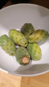 a white plate with green fruit on a table at Maison de vacances in Ventiseri