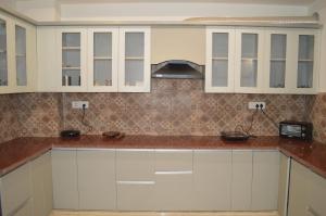 a kitchen with white cabinets and a counter top at Aarya Rishikesh - Luxurious 2 BHK in Rishīkesh