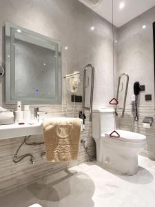 a bathroom with a sink and a toilet and a mirror at Al Gosaibi Hotel-Villa in Al Khobar