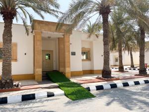 a building with palm trees in a courtyard at Al Gosaibi Hotel-Villa in Al Khobar