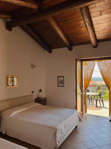 a bedroom with a bed and a patio with a table at Agriturismo Le Viole in Barolo