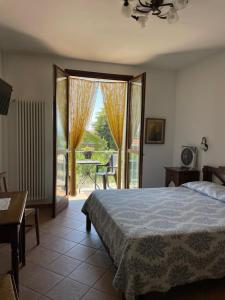 バローロにあるアグリツーリズモ レ ヴィオレのベッドルーム1室(ベッド1台付)、スライド式ガラスドアが備わります。