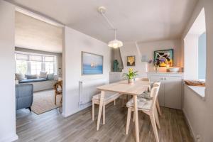 a dining room and living room with a table and chairs at Wonderful cottage with sun-filled terrace in Aldringham