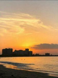 サンファンにあるSTARFISH LUXURY APARTMENT BEACH IIの建物を背景にしたビーチの夕日