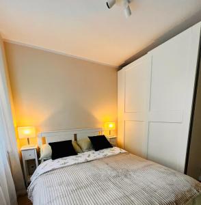 1 dormitorio con 1 cama con 2 lámparas en ambos lados en Apartament Harmony en Tychy