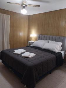 a bedroom with a large bed with two pillows on it at Tu Casita de Paso in General Acha