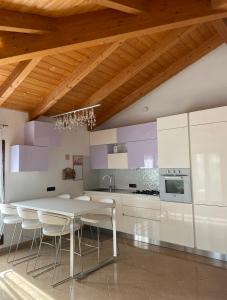 - une cuisine avec une table et des chaises blanches dans l'établissement Appartamento tra verde e città, à Bologne