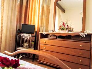 - une chambre avec une commode et un miroir dans l'établissement Tanias House, à Siátista