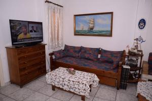 a living room with a couch and a tv at Unique & cozy seaview apartment. in Loutraki