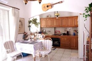 a kitchen with a table and chairs and a guitar at Unique & cozy seaview apartment. in Loutraki