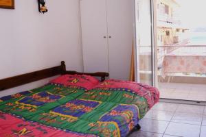 Una cama con un edredón colorido en un dormitorio en Unique & cozy seaview apartment. en Loutraki