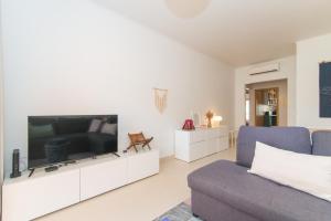 uma sala de estar com uma grande televisão de ecrã plano em Casa Nobre 2BDR Apartment w Pool & Patio em Conceição