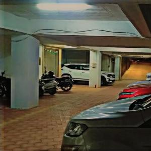 Hotel Crown Inn في دهرواد: كراج للسيارات ودراجة نارية متوقفة فيه