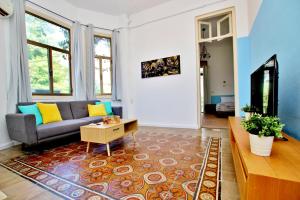 ein Wohnzimmer mit einem Sofa und einem Tisch in der Unterkunft beautiful 3 rooms apartment at neve tzedek in Tel Aviv