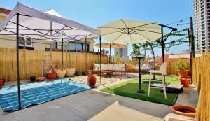 a backyard with a swimming pool and two umbrellas at beautiful 3 rooms apartment at neve tzedek in Tel Aviv