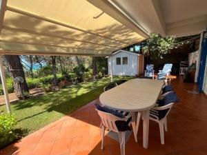 un patio con mesa y sillas bajo un dosel en Casa Quercia, en Quercianella