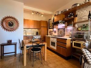 クエルチアネッラにあるCasa Querciaのキッチン(テーブル、椅子、テーブル、コンロ付)