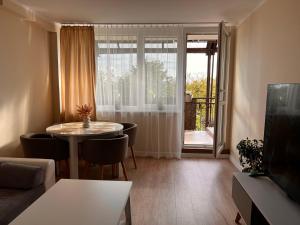 a living room with a table and chairs and a window at Harmony in Tychy