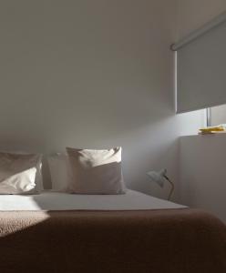 a bedroom with a bed with white sheets and pillows at A Padaria Farmhouse in Cinfães