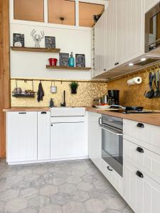 a kitchen with white cabinets and a tile floor at Anouste Lou Bercail - cocon entièrement rénové avec vue sur la montagne in Campan