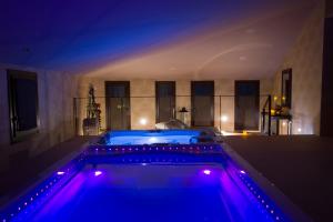 Cal Barber في Botarell: حوض استحمام ساخن في غرفة مع أضواء أرجوانية