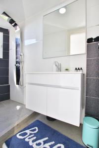 ein Badezimmer mit einem weißen Waschbecken und einem blauen Teppich in der Unterkunft beautiful 3 rooms apartment at neve tzedek in Tel Aviv