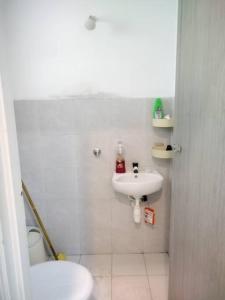 Baño blanco con lavabo y aseo en Malay Homestay di Meru, Klang en Kapar