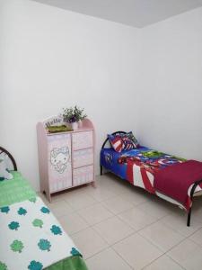 a room with two beds and a dresser and a bed sidx sidx sidx sidx at Malay Homestay di Meru, Klang in Kapar