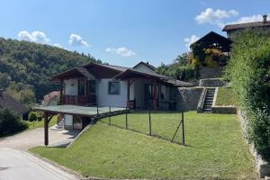 mały domek na trawiastym wzgórzu z gankiem w obiekcie Family House Simba w mieście Šmarješke Toplice