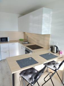 a kitchen with a counter with two wine glasses at Nový, klimatizovaný, útulný apartmán s garážou, 5 min od letiska in Bratislava