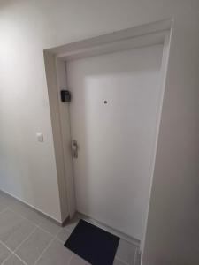 a white door in a room with a black rug at Nový, klimatizovaný, útulný apartmán s garážou, 5 min od letiska in Bratislava