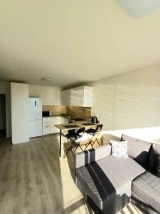 Nový, klimatizovaný, útulný apartmán s garážou, 5 min od letiska في براتيسلافا: غرفة معيشة مع أريكة وطاولة