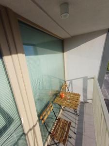 a balcony with a bench and a glass window at Nový, klimatizovaný, útulný apartmán s garážou, 5 min od letiska in Bratislava