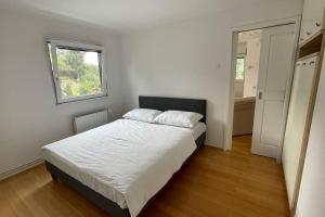 biała sypialnia z łóżkiem i oknem w obiekcie Family House Simba w mieście Šmarješke Toplice