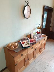a buffet with food on it with a clock on the wall at Pension Thüringer Wald in Reichmannsdorf