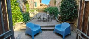 um pátio com 2 cadeiras azuis e uma mesa em Palazzo centro storico em Soriano nel Cimino
