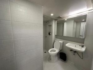 a bathroom with a white toilet and a sink at Letter Better Home in Ban Bo Sai Klang