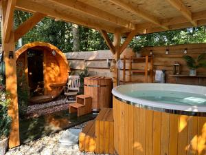 eine Whirlpool-Badewanne im Hinterhof mit Kamin in der Unterkunft CHALET HARMONY prive WELLNESS in Putten