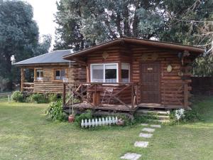 a log cabin with a porch and a window at Pualy Resort & Spa in Belén de Escobar