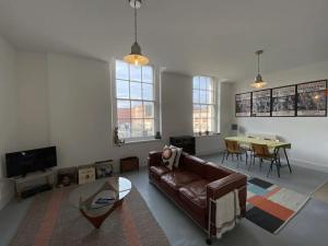 a living room with a leather couch and a table at 2-bed in central Margate in Kent