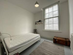 a white room with a bed and a window at 2-bed in central Margate in Kent