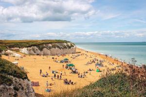 a group of people on a beach near the ocean at 2-bed in central Margate in Kent