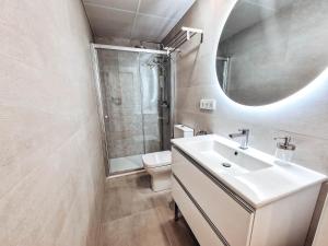 Un baño con lavabo, inodoro y espejo. en Apartamento TIENDAS 8, en Almería 42 fotos más