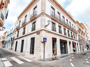 una mujer parada frente a un edificio en una calle en Apartamento TIENDAS 8 en Almería