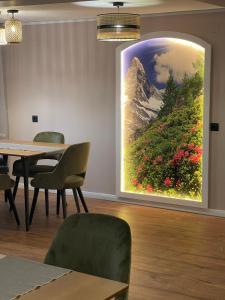 una gran pintura de una montaña en una pared en una habitación en Pensiunea Padurea Verde, en Moieciu de Sus