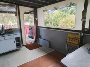 Aurec-sur-Loire的住宿－mobile home aux Rives D'Aurec，客房设有2扇窗户、书桌和1张床。