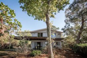 une maison avec des arbres devant elle dans l'établissement Pyla Villa DE LA DUNE promo vacances d'été, à La Teste-de-Buch