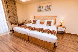 una habitación de hotel con 2 camas en una habitación en The Hut Restaurant & Boutique Hotel, en Kigali