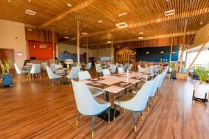 une salle à manger avec des tables et des chaises blanches dans l'établissement The Hut Restaurant & Boutique Hotel, à Kigali